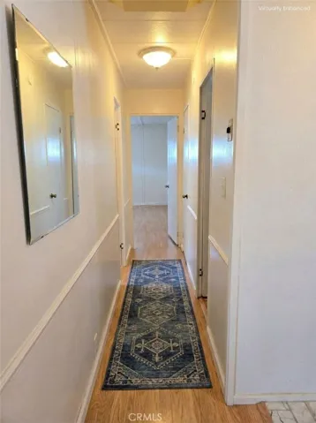 Image has been digitally staged. View from living room/laundry area down hall to bedrooms.