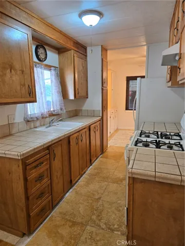 Original image. View of kitchen and dining room from laundry area.