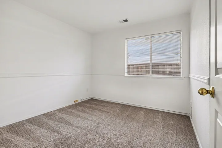Spare room featuring light carpet and baseboards