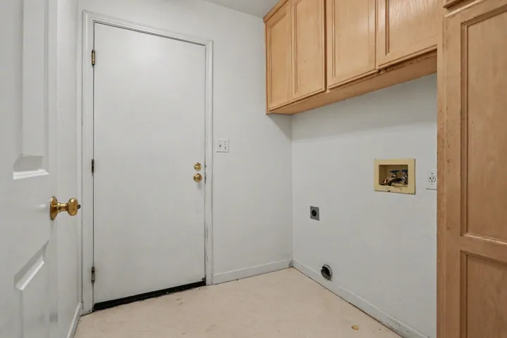 Laundry area with light flooring, electric dryer hookup, cabinet space, and washer hookup