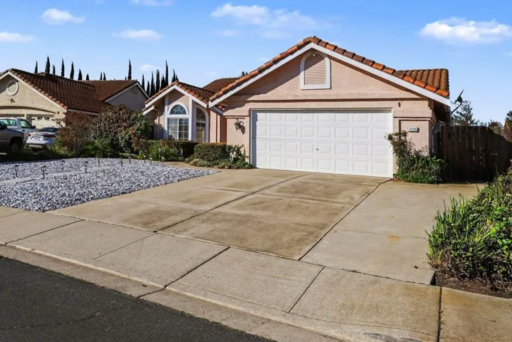 Mediterranean / spanish house with a tile roof, concrete driveway, stucco siding, and an attached garage