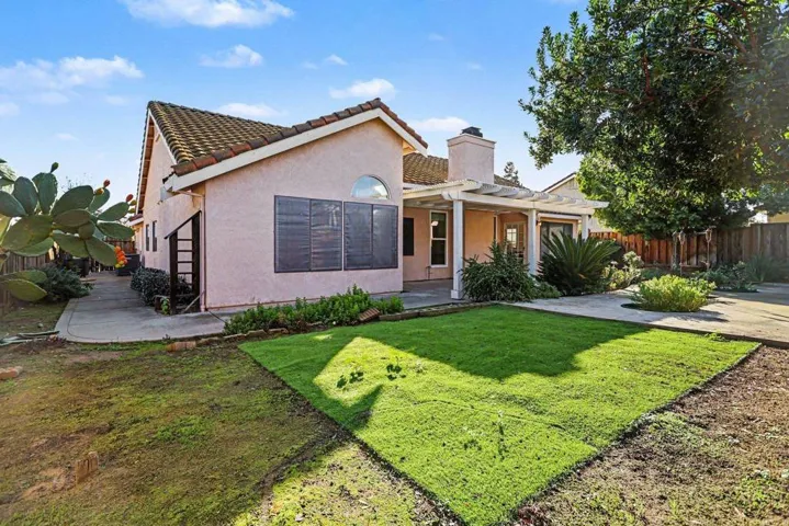 View of front of property with a chimney, stucco siding, and a tiled roof