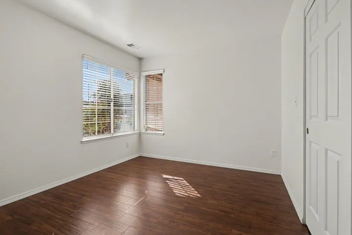 Unfurnished bedroom with dark wood finished floors and baseboards