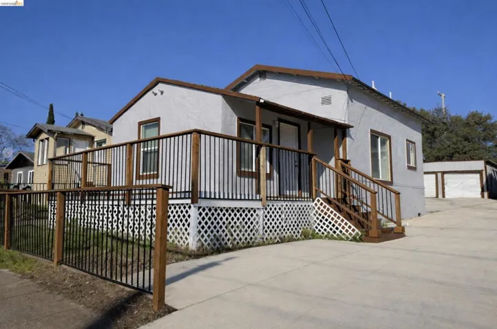 View of front facade featuring an outdoor structure, stucco siding, and a detached garage