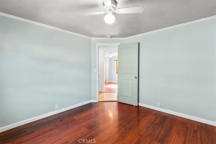 Guest bedroom with wood flooring