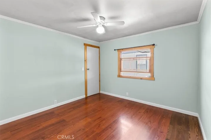 Guest bedroom with wood flooring
