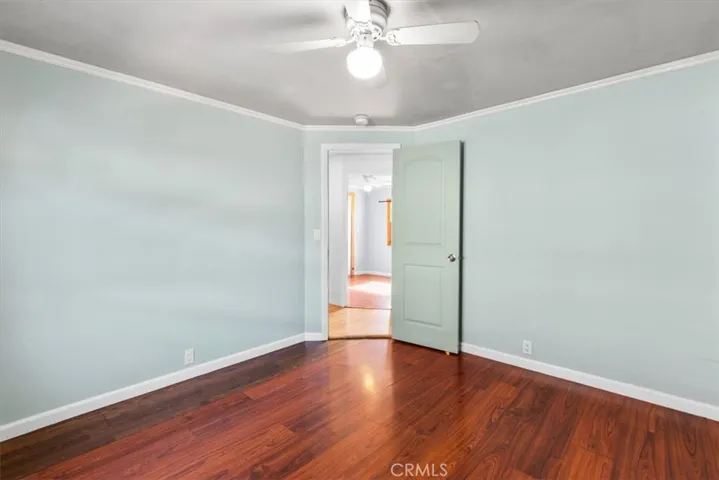 Guest bedroom with wood flooring