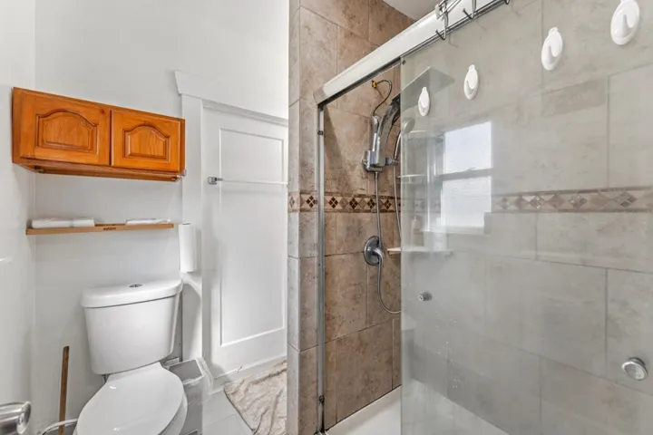 Bathroom with a shower stall and toilet