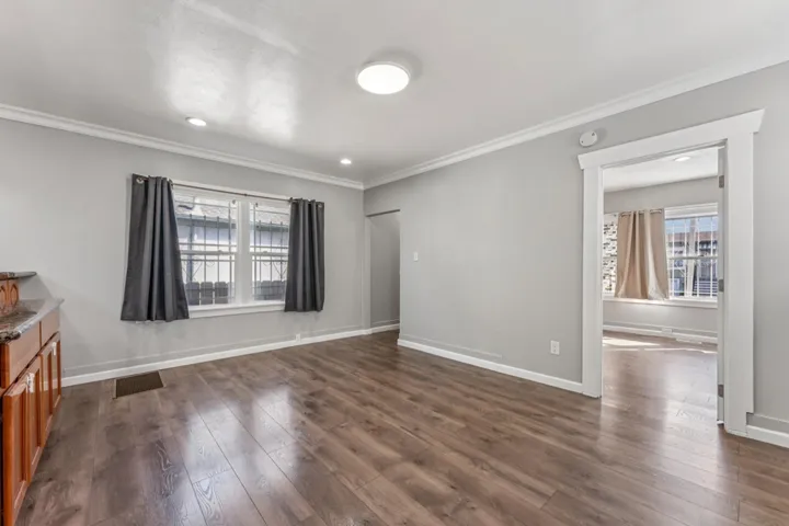Spare room with ornamental molding, dark wood-style flooring, and recessed lighting