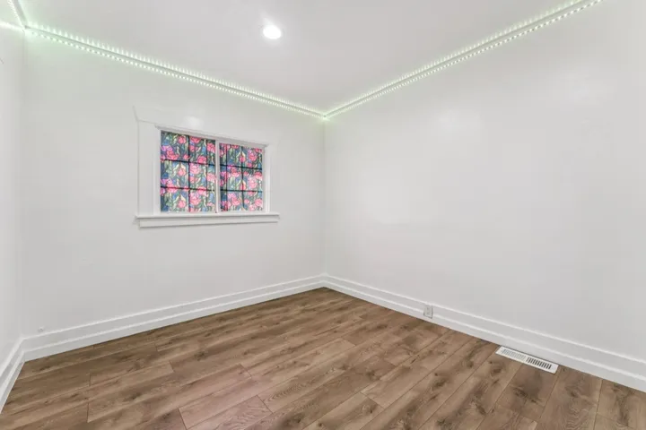 Unfurnished room with wood finished floors and baseboards