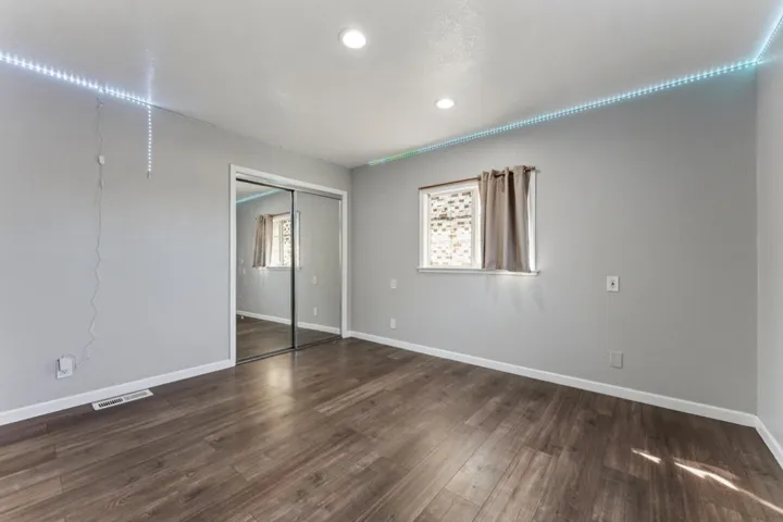Unfurnished bedroom featuring a closet and dark wood-type flooring
