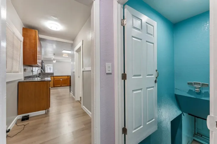 Hallway featuring light wood finished floors and a textured wall