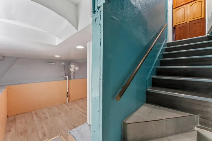 Stairs featuring wood finished floors and recessed lighting