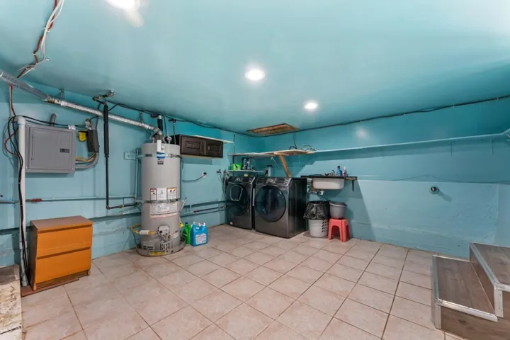 Laundry area featuring separate washer and dryer, water heater, electric panel, and recessed lighting