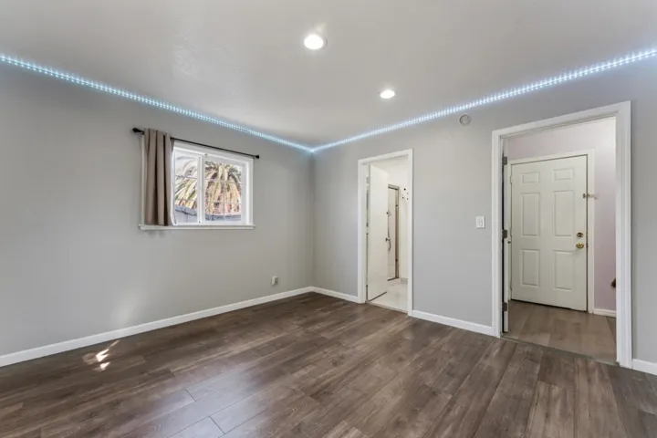 Unfurnished bedroom featuring baseboards and dark wood-style floors