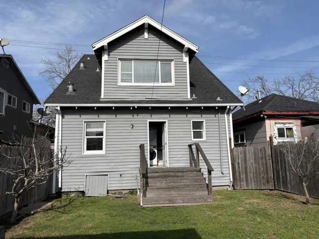 Back of property featuring a fenced backyard and a shingled roof