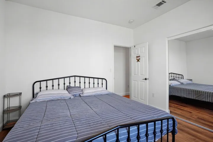Bedroom featuring dark wood-type flooring and baseboards