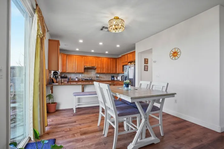 Dining room with dark wood-style floors and hanging lights