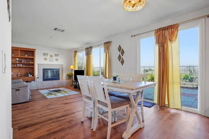 Dining room with a fireplace, wood finished floors, and built in features