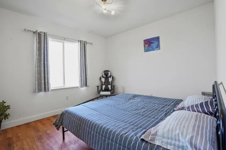 Bedroom featuring baseboards and wood finished floors