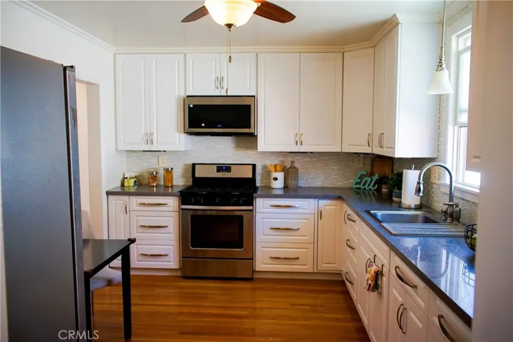 Kitchen is light and views custom tile mural on private driveway. Glass backsplash and luxury corian stone counters.