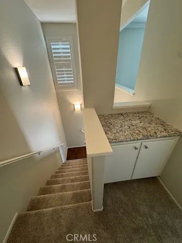 Stairway to Bedroom has Storage cabinet, High Ceilings, and Shutters