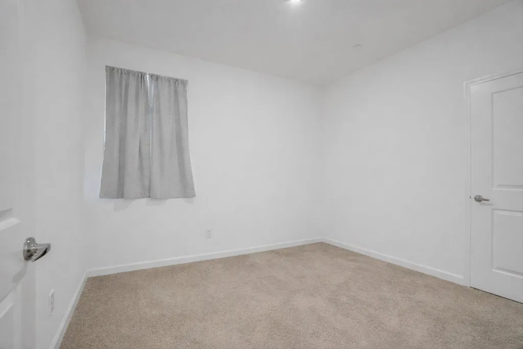 carpeted empty room featuring baseboards