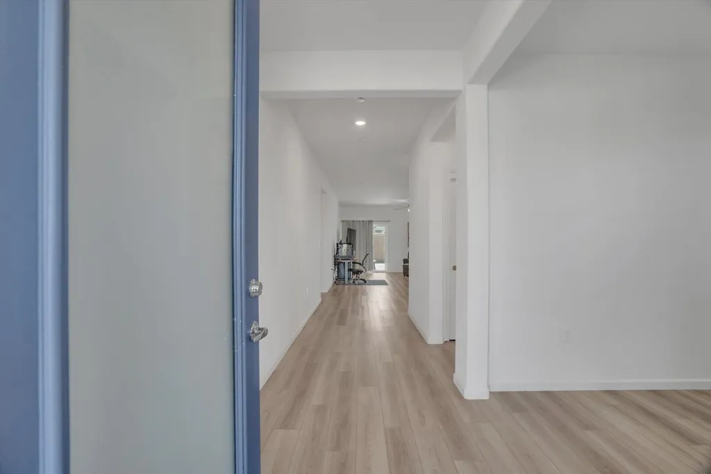 hall with light wood finished floors and recessed lighting