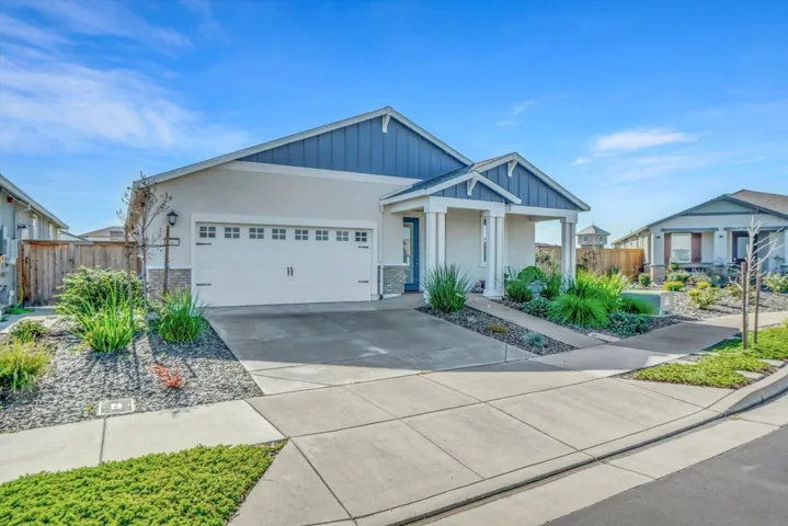 craftsman house featuring concrete driveway, an attached garage, stucco siding, board and batten siding, and stone siding