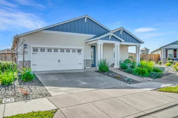 craftsman house with an attached garage, driveway, board and batten siding, and stucco siding