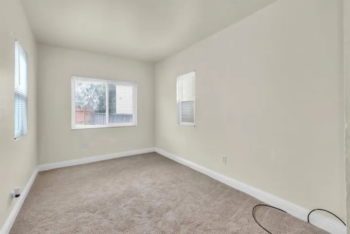 Carpeted empty room featuring plenty of natural light