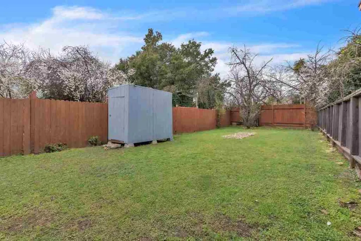 Fenced backyard with a storage shed