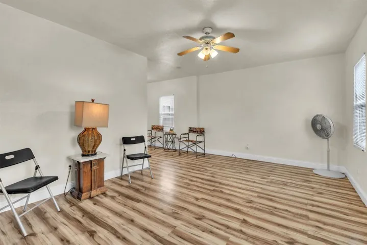 Sitting room featuring light wood-type flooring and a ceiling fan