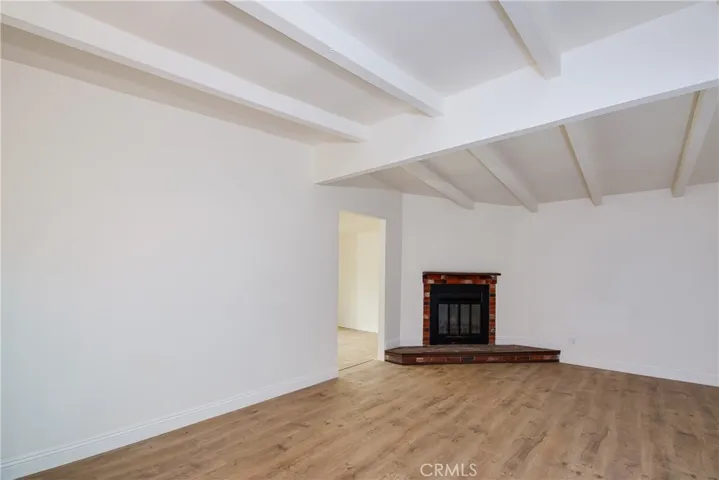 Livingroom with open beams and fireplace. Bonus room to the left of the fireplace.