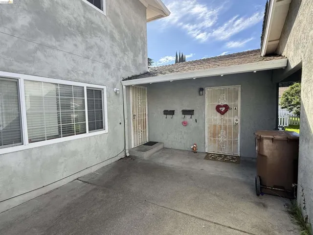 View of exterior entry with stucco siding and a patio area