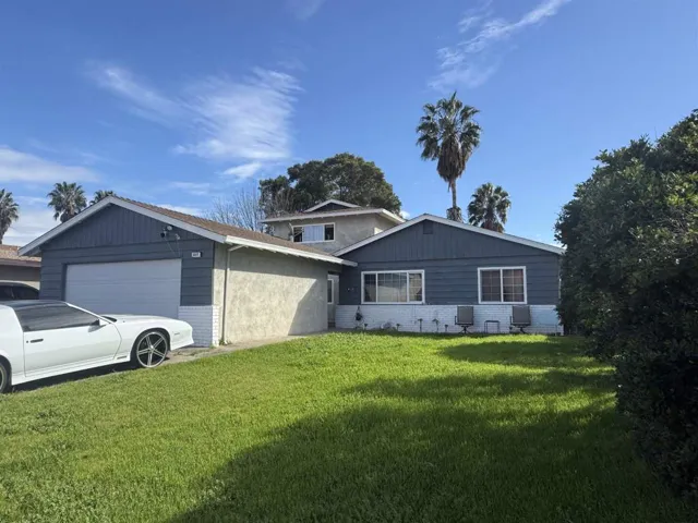 Single story home with brick siding, a front yard, and an attached garage