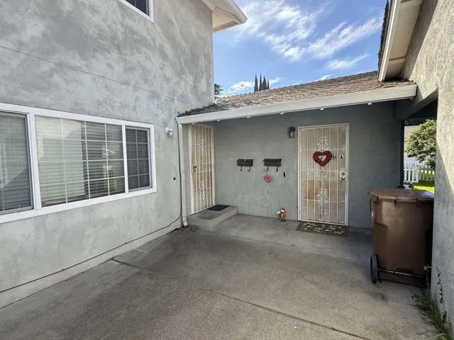 View of exterior entry with stucco siding and a patio area