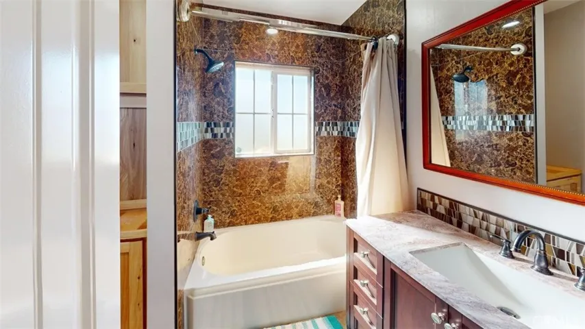 Guest bathroom with tub and overhead shower.