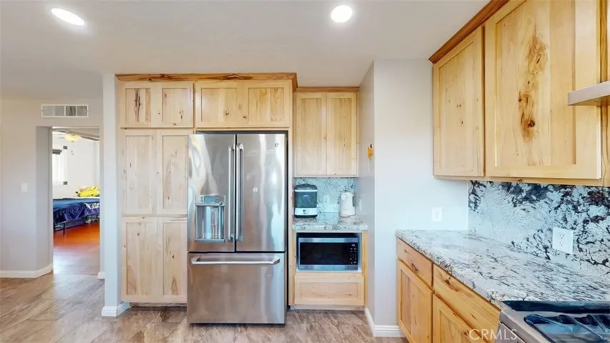 Kitchen looking at refrigerator and microwaive with bedroom 1 to the left