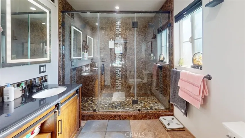 Primary bathroom step in shower with shower heads on each side