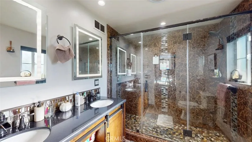 Primary bathroom with double sinks and beautiful step in shower