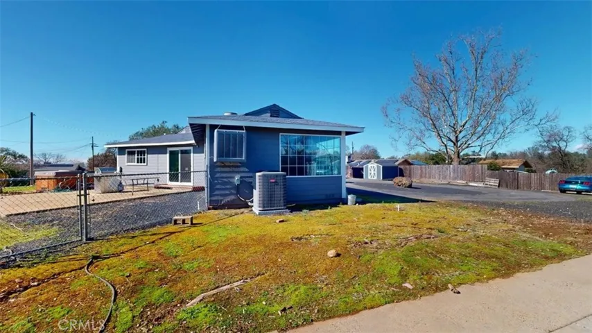 Standing on side yard cement area looking towards home and back area with hot tub