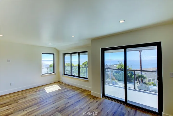 Living room and slider to outside deck with ocean view of the coaset line.