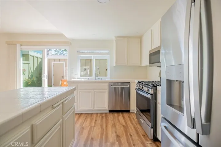 KITCHEN WITH WIDE COUNTERTOP --- DOOR TO GARAGE OFF PATIO