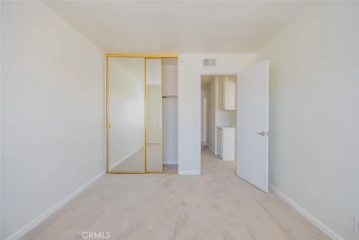 Secondary Bedroom with Mirrored doors, note linen storage in hallway
