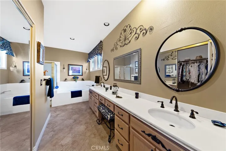 Primary bath with 2 sinks, upgraded fixtures and mirrors, a soaking tub and a separate shower.