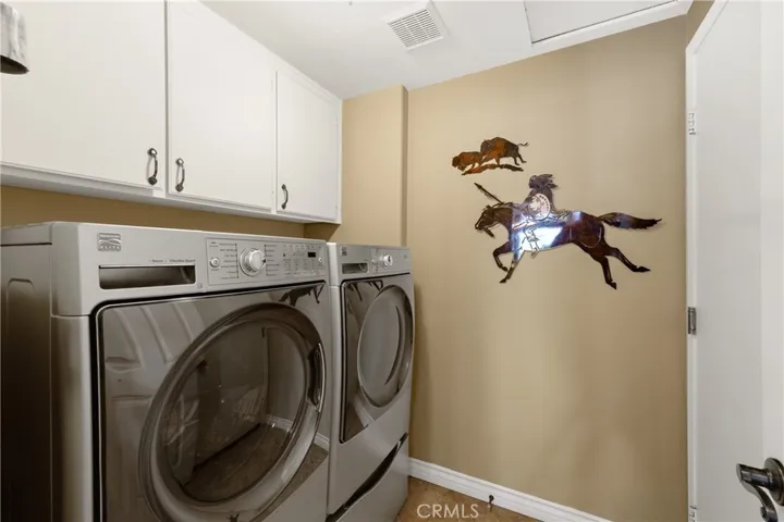 Indoor laundry room with storage cabinets.