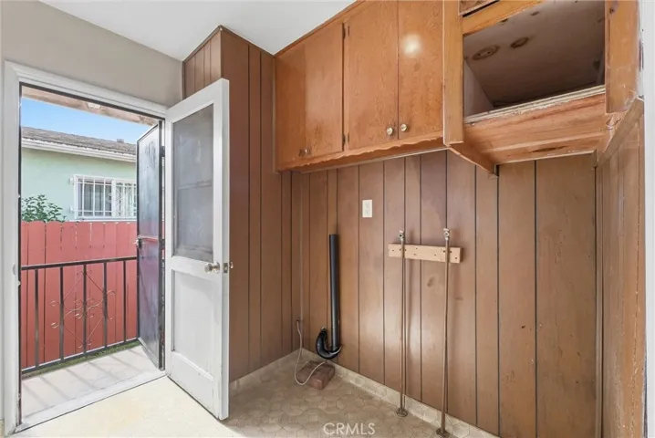 Laundry room with extra cabinets and side door.