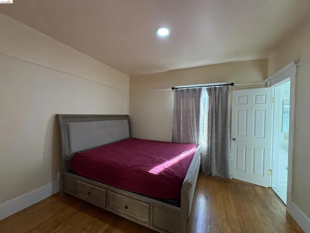 Bedroom featuring wood finished floors and baseboards