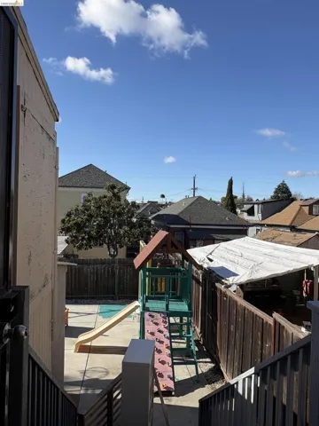 Deck with a playground, a patio area, a residential view, a fenced backyard, and a pool